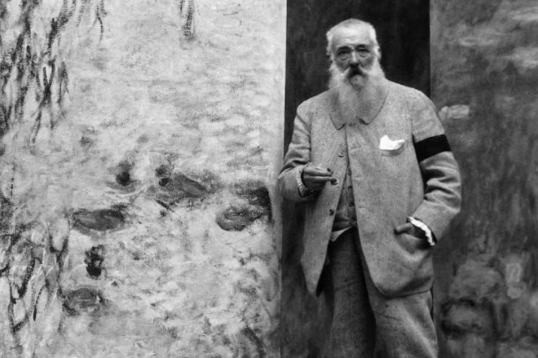 Claude Monet posa di fronte ai suoi quadri con le ninfee.